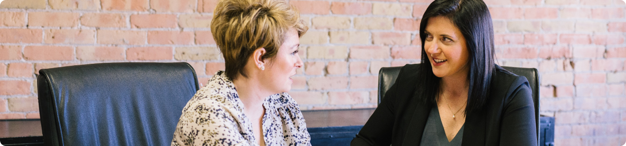 Two women having a discussion while seated.