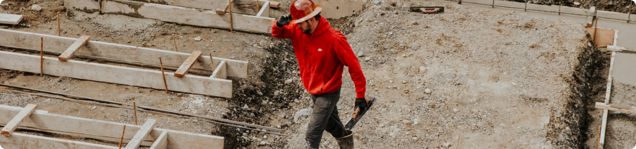 A man in a hard hat walking in a construction site.