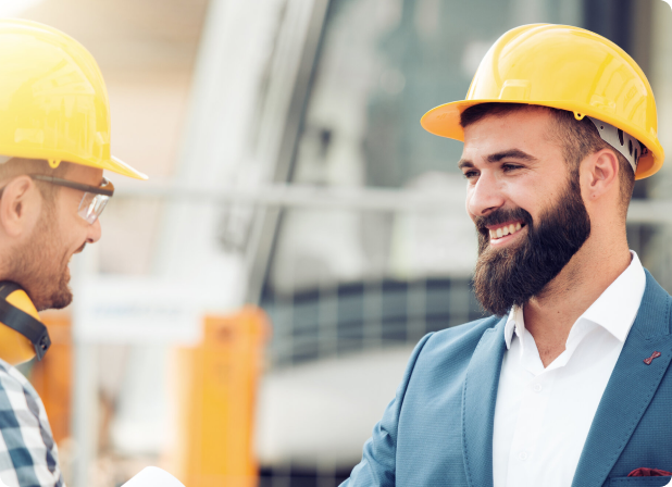 Two male engineers smiling at each other.