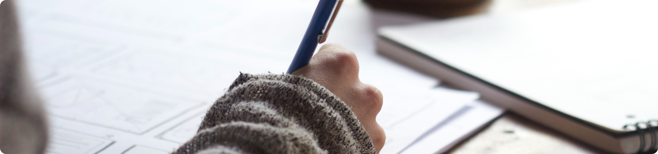 The hand of a woman writing in a book.